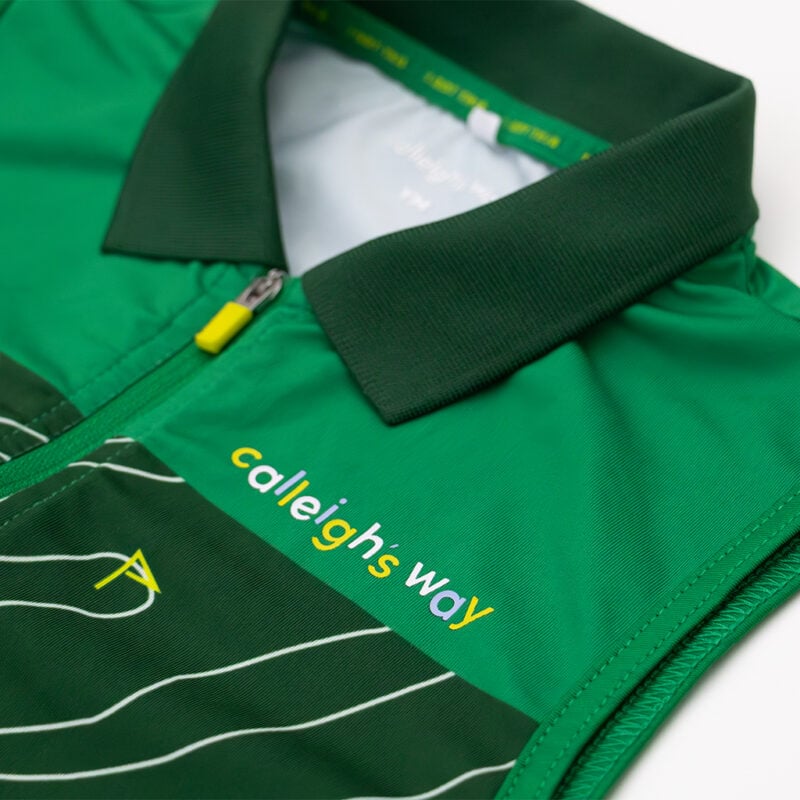 Close-up of a green Calleigh’s Way sleeveless golf polo with a quarter-zip collar, featuring the brand logo and a golf course-inspired pattern on the front.