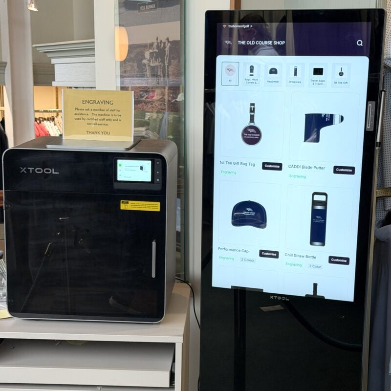 Photo of The Old Course Shop’s in-store customization station, featuring an xTool engraving machine and touchscreen displaying personalized golf merchandise options.
